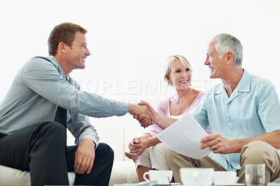 Buy stock photo Finance, old couple or advisor in house with handshake, investment deal or loan approval in retirement. Happy, senior people or consultant with shaking hands, thank you or agreement on pension fund.