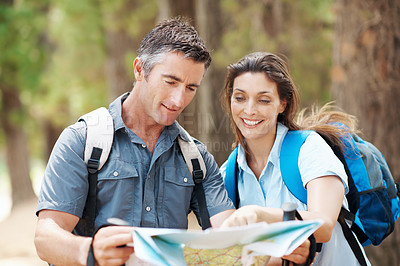 Buy stock photo Map, nature and happy couple with hiking navigation for outdoor destination or route in wilderness. Man, woman or hikers with tour guide for trekking path, direction or travel together in forest
