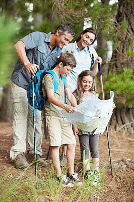 Buy stock photo Happy, family and forest with map for hiking navigation, outdoor destination or tracking route. Dad, mom and children with tour guide on trip for trekking path, direction or travel together in nature