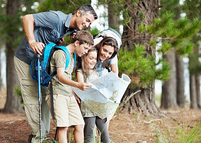 Buy stock photo Happy, family and hiking with map in nature for navigation, outdoor destination or tracking route. Dad, mom and children with tour guide on trip for trekking path, direction or travel in forest