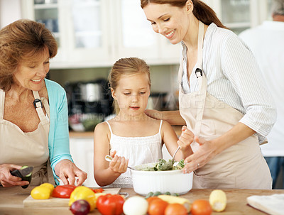 Buy stock photo Salad, grandmother and girl with mom for cooking, culinary lesson and helping with lunch in kitchen. Home, generations and happy child with ingredients, vegetables and healthy dinner with family