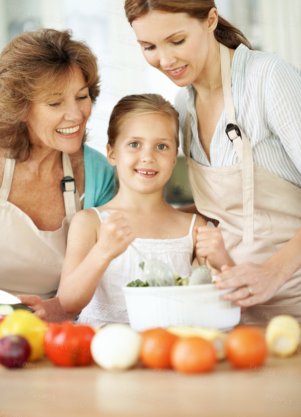 Buy stock photo Cooking, portrait and child with salad in kitchen for meal prep, help and lunch with mom and grandma. Home, generations and happy girl with ingredients, vegetables and healthy dinner with family