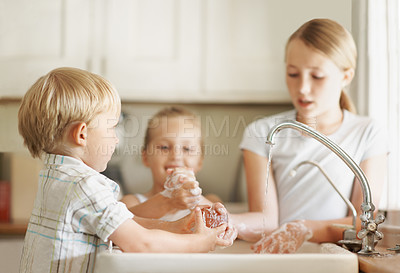 Buy stock photo Sink, hygiene and children in kitchen, washing hands and siblings with soap for germ removal in home. Kids, self care and bacteria prevention with tap liquid, cleaning routine and family in house
