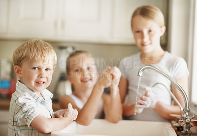 Buy stock photo Happy, portrait and boy in bathroom washing hands for hygiene, wellness and cleaning with siblings. Smile, home and child with family by sink for soap, foam and disinfection for germ prevention