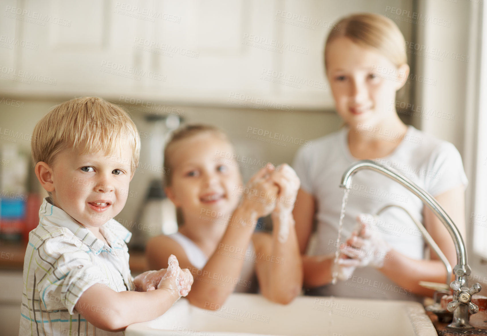 Buy stock photo Happy, portrait and boy in bathroom washing hands for hygiene, wellness and cleaning with siblings. Smile, home and child with family by sink for soap, foam and disinfection for germ prevention