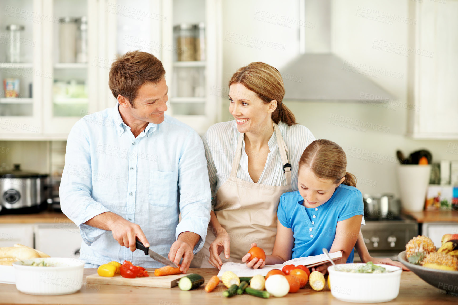 Buy stock photo Recipe, vegetables and family in kitchen for cooking, learning and help with meal prep together. Happy, ingredients and girl with mom, dad and cook book for cutting, healthy dinner and lunch in home