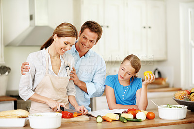 Buy stock photo Happy, parents and child with vegetables in kitchen for meal prep, dinner or help in home. Kid, daughter or learning food with mom, dad or natural organic ingredients for family recipe in house