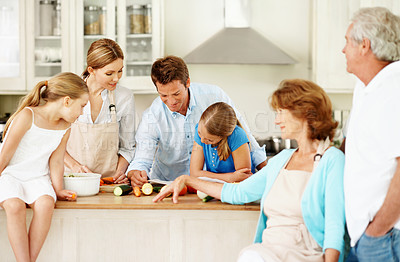 Buy stock photo Family, cooking and kids in kitchen with vegetables, recipe book and salad for meal prep. Generations, home and children with mom, dad and grandparents for help with lunch, dinner and ingredients