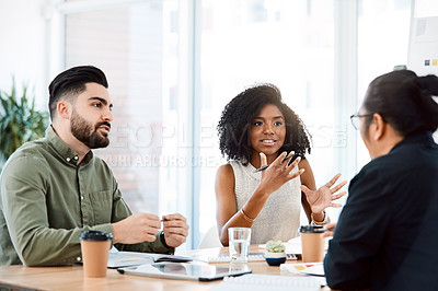 Buy stock photo Shot of a group of young businesspeople having a meeting in a modern office