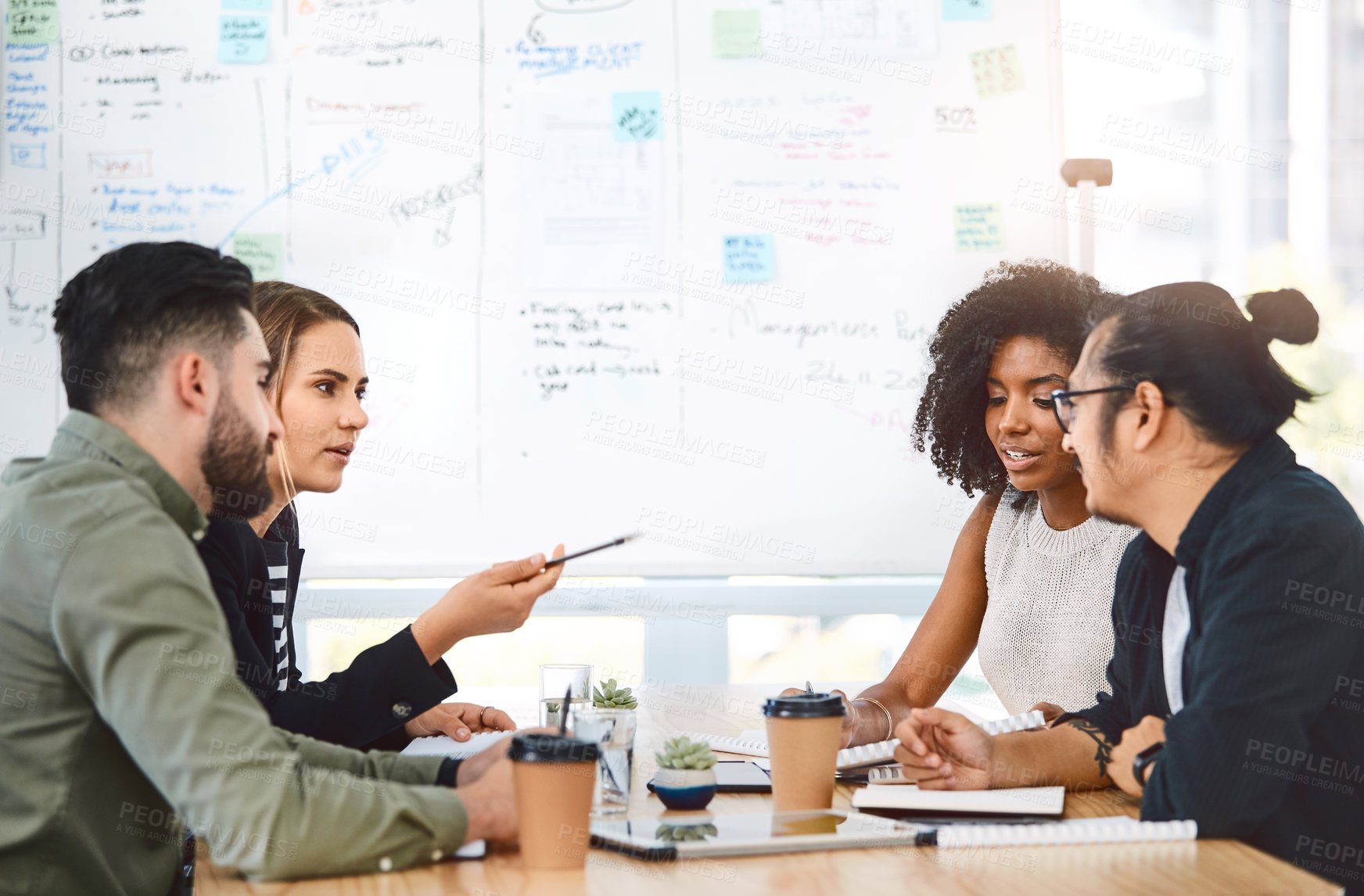 Buy stock photo Shot of a group of young businesspeople having a meeting in a modern office