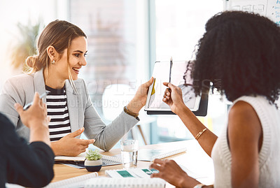 Buy stock photo Shot of young businesspeople using a digital tablet during a meeting in a modern office