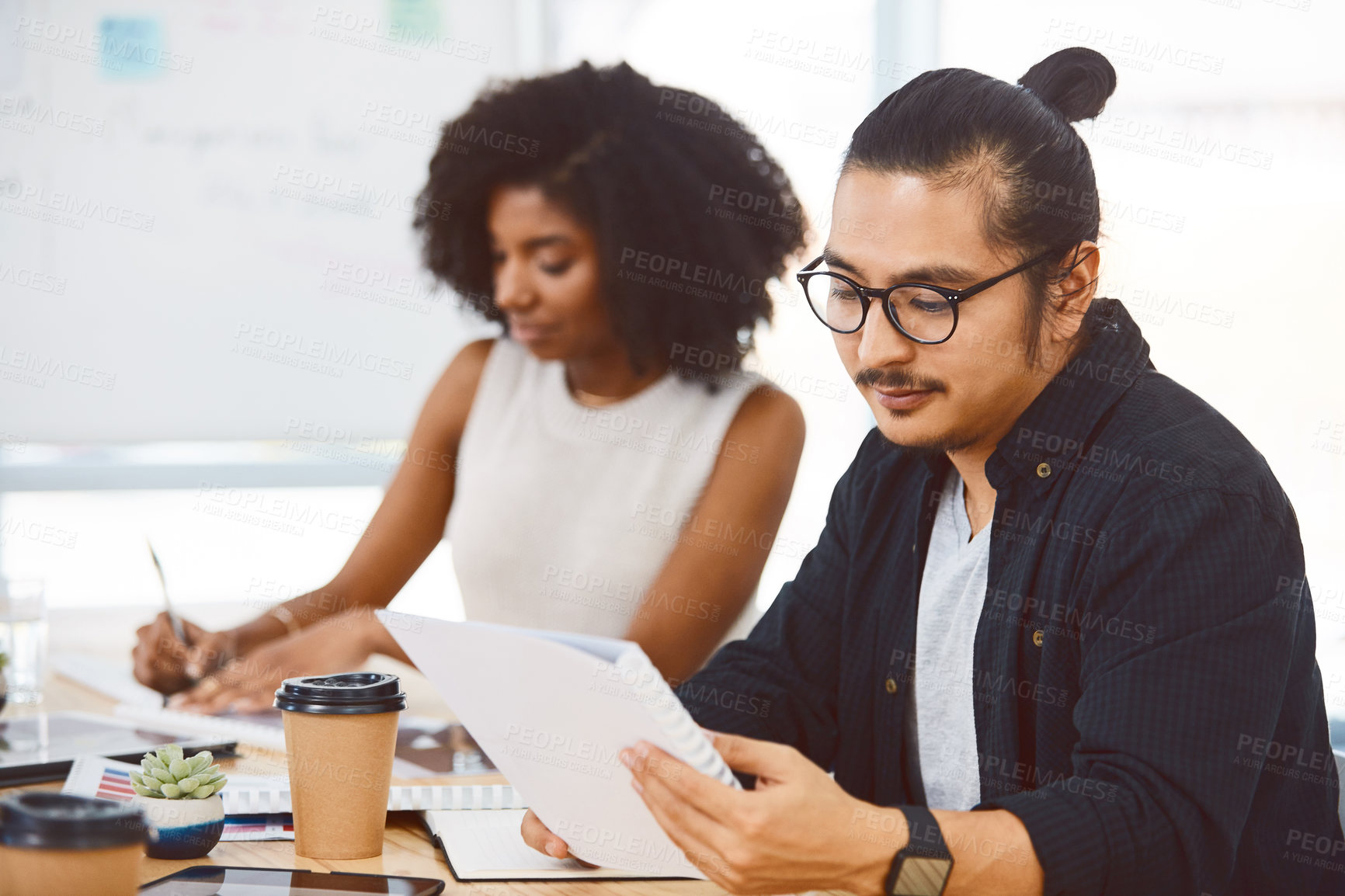 Buy stock photo Shot of a young businessman and businesswoman having a meeting in a modern office