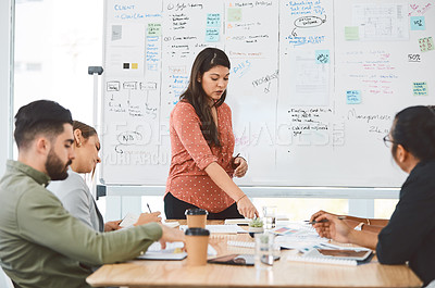 Buy stock photo Shot of a young businesswoman delivering a presentation to her colleagues in a modern office