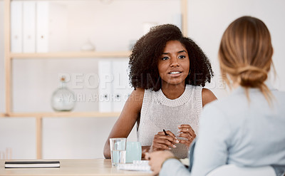 Buy stock photo Shot of two young businesswomen having a meeting in a modern office