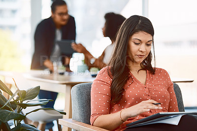 Buy stock photo Shot of a young businesswoman using a digital tablet in a modern office