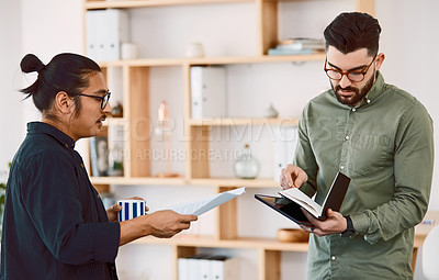 Buy stock photo Shot of two young businessmen having a meeting in a modern office
