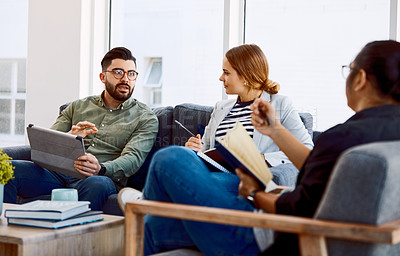 Buy stock photo Shot of a group of young businesspeople having a meeting in a modern office
