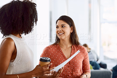 Buy stock photo Shot of two young businesswomen having a discussion in a modern office