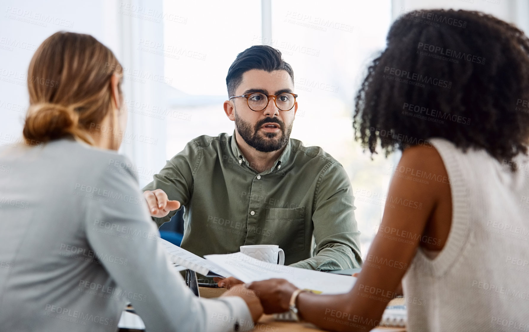 Buy stock photo Shot of a group of young businesspeople having a meeting in a modern office
