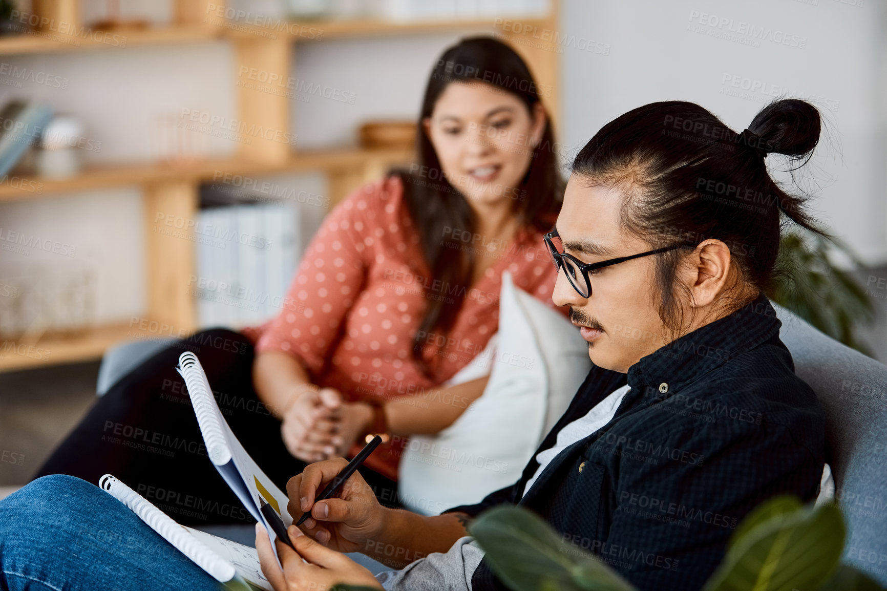 Buy stock photo Shot of a young businessman and businesswoman having a meeting in a modern office