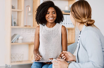 Buy stock photo Shot of two young businesswomen having a discussion in a modern office
