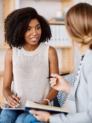 Buy stock photo Shot of two young businesswomen having a discussion in a modern office