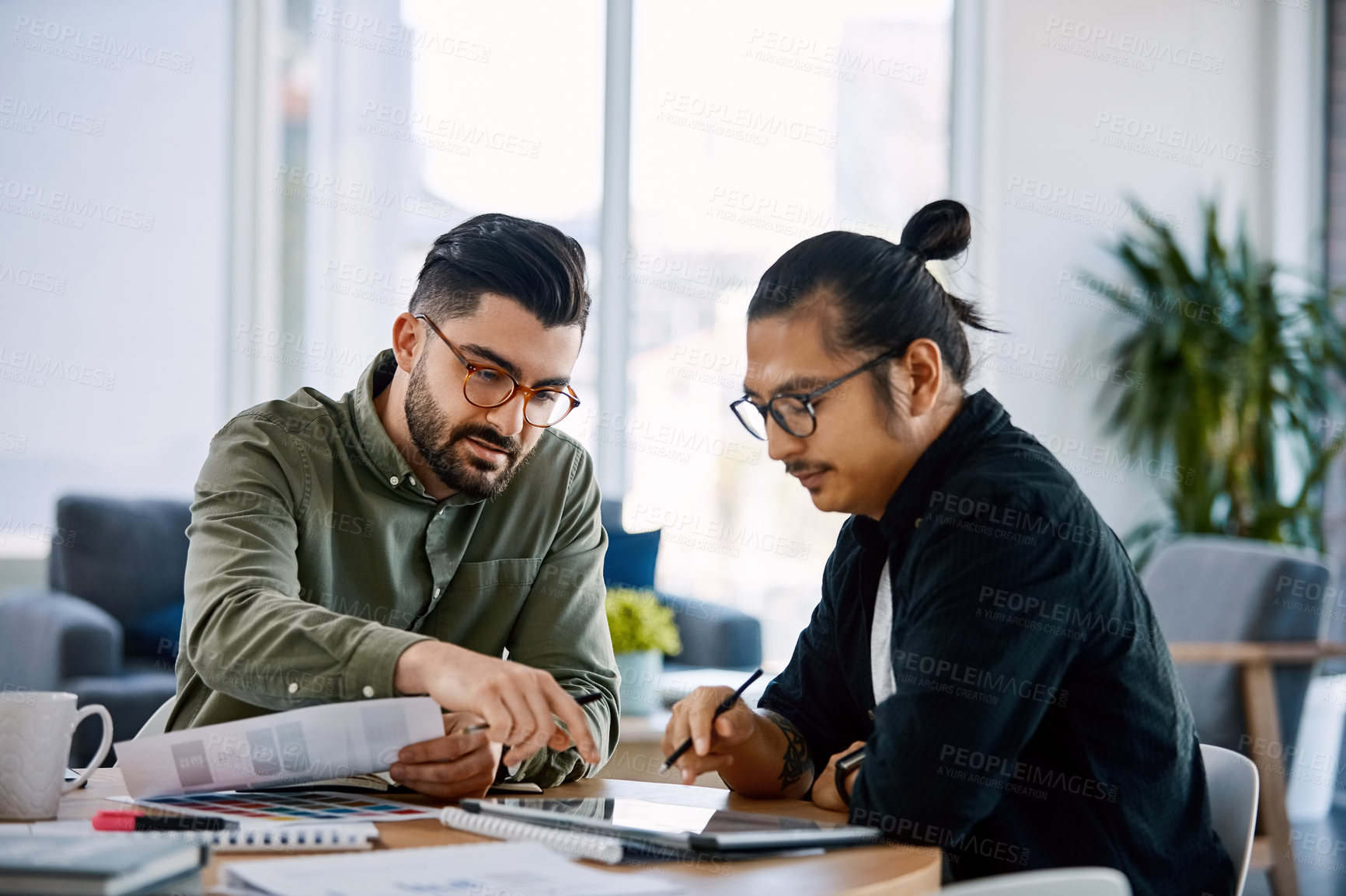 Buy stock photo Shot of two young businessmen having a meeting in a modern office