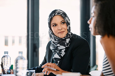 Buy stock photo Shot of two young businesswomen having a meeting together at work