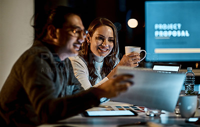 Buy stock photo Shot of a young businessman and businesswoman having a late night meeting at work
