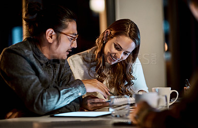 Buy stock photo Shot of a group of young businesspeople having a late night meeting at work