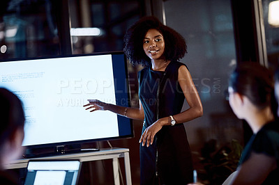 Buy stock photo Shot of a young businesswoman delivering a presentation during a late night meeting at work