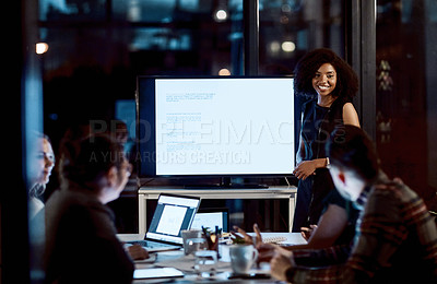 Buy stock photo Shot of a young businesswoman delivering a presentation during a late night meeting at work