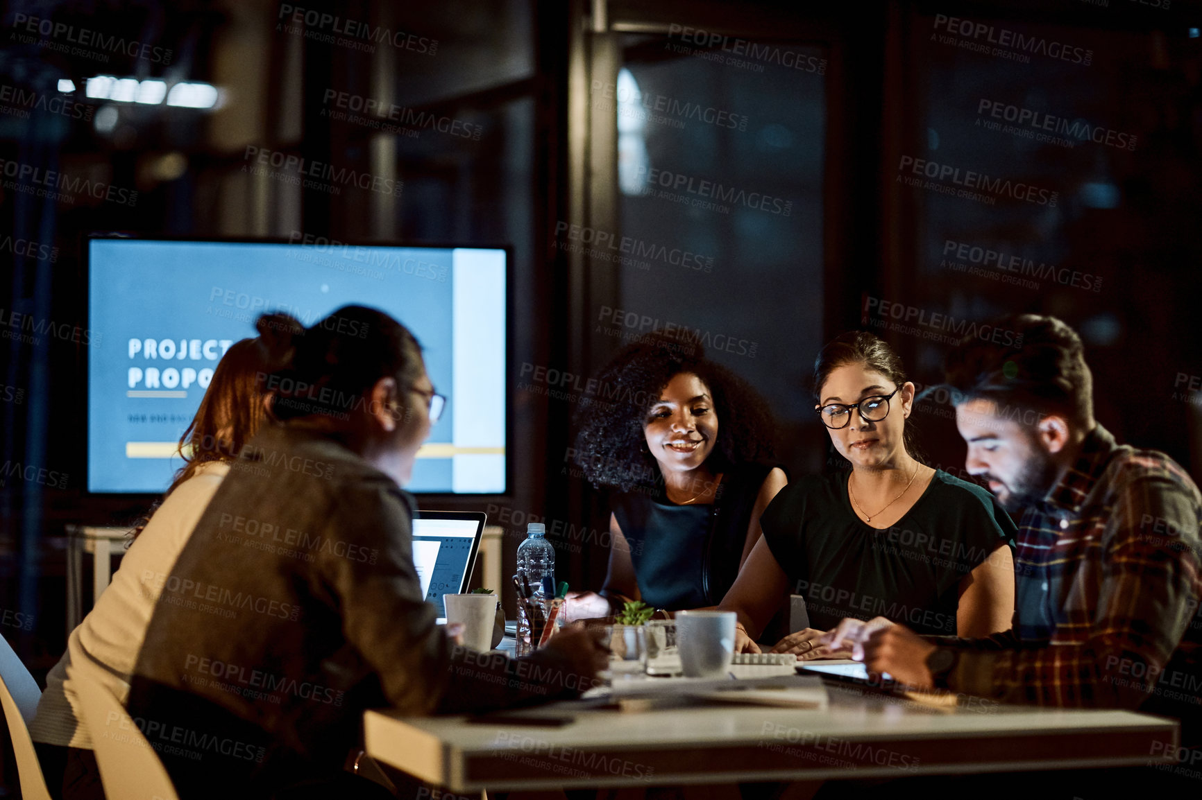 Buy stock photo Shot of a young businessman using a digital tablet during a late night meeting at work