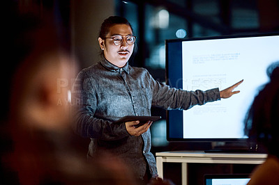Buy stock photo Shot of a young businessman delivering a presentation during a late night meeting at work