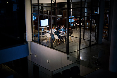 Buy stock photo Shot of a group of young businesspeople having takeout during a late night meeting at work