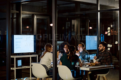 Buy stock photo Shot of a group of young businesspeople having takeout during a late night meeting at work