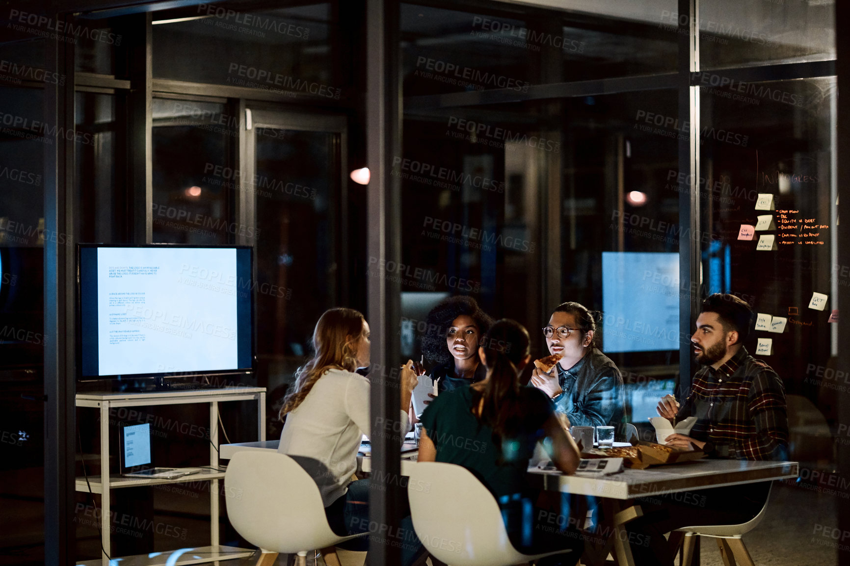 Buy stock photo Overtime, meeting and team with fast food in office, brand awareness and talk with takeout at night. Marketing, collaboration and happy people with paperwork, discussion and working late with meal