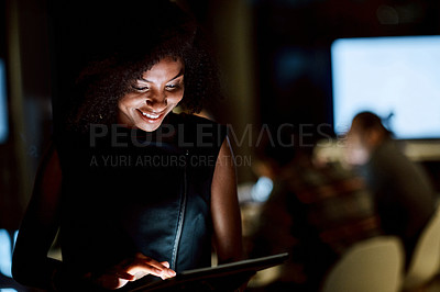 Buy stock photo Shot of a young businesswoman using a digital tablet during a late night at work