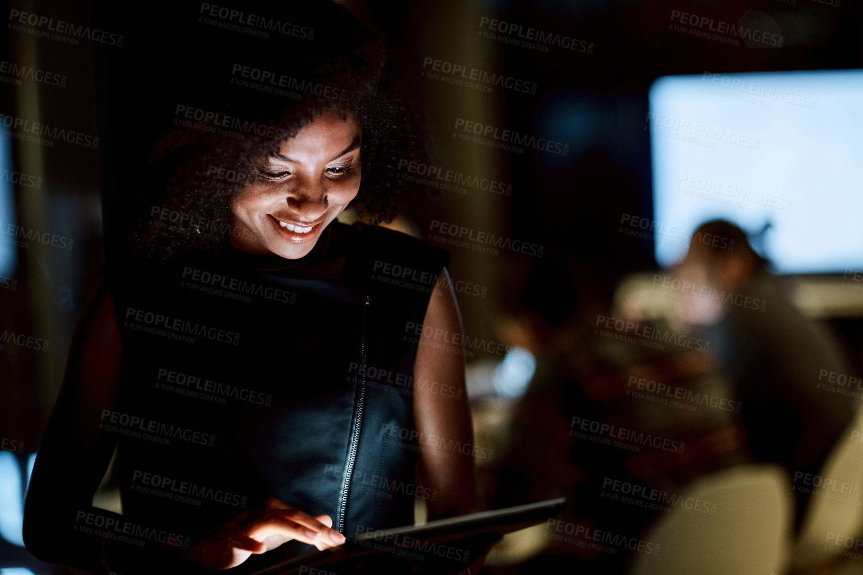 Buy stock photo Shot of a young businesswoman using a digital tablet during a late night at work
