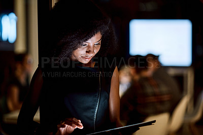 Buy stock photo Shot of a young businesswoman using a digital tablet during a late night at work