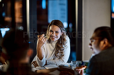 Buy stock photo Shot of a group of young businesspeople having takeout during a late night meeting at work