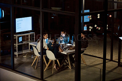 Buy stock photo Shot of a group of young businesspeople having takeout during a late night meeting at work