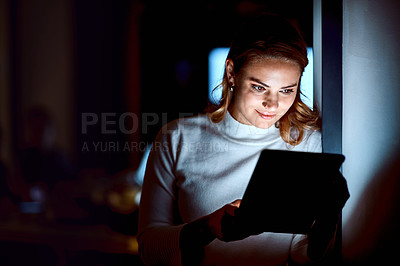 Buy stock photo Shot of a young businesswoman using a digital tablet during a late night at work