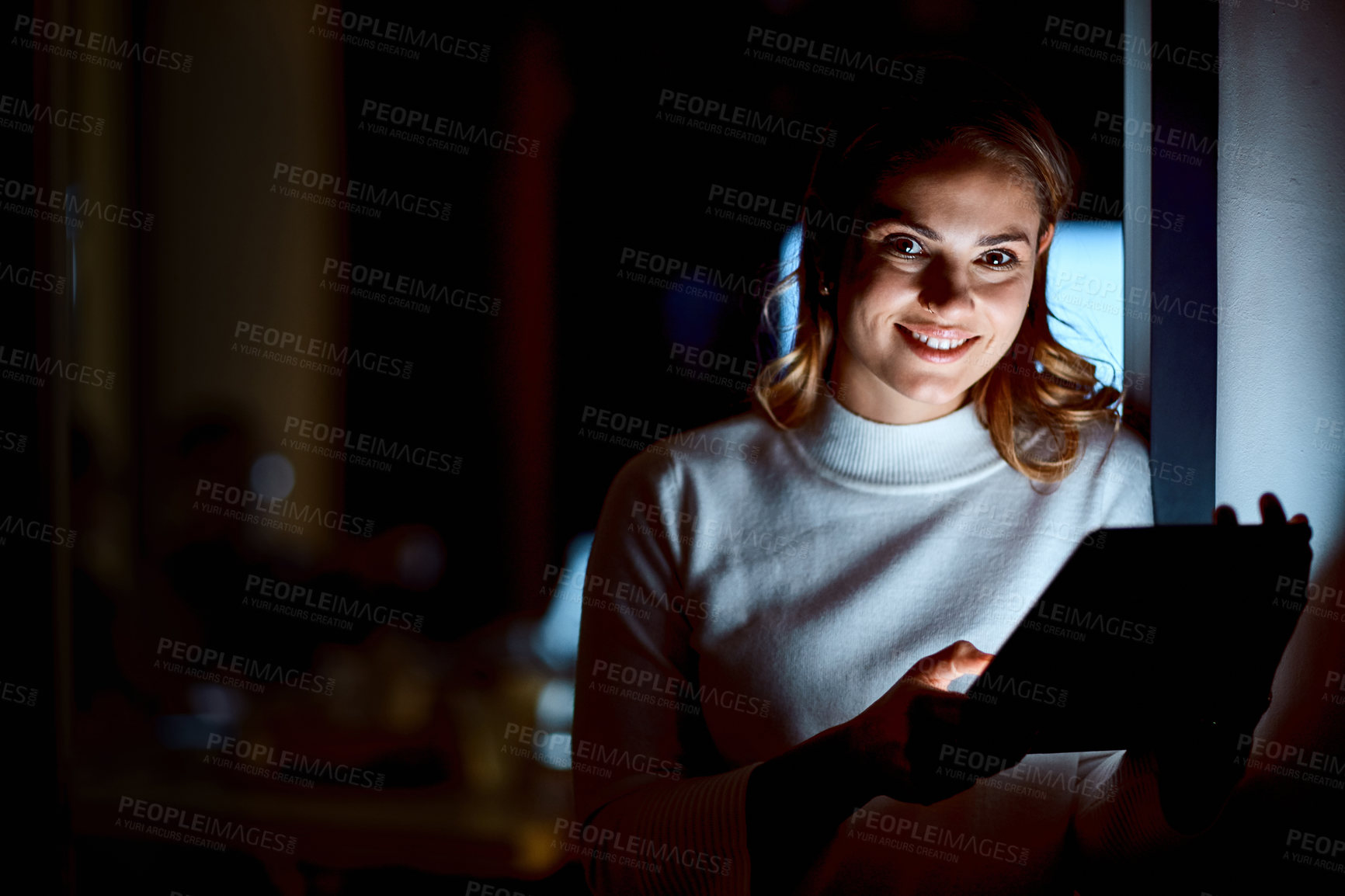 Buy stock photo Shot of a young businesswoman using a digital tablet during a late night at work