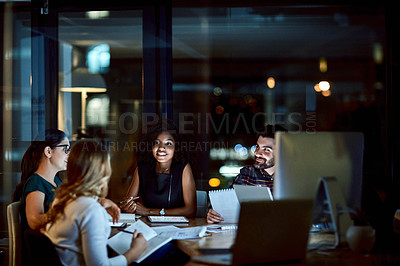 Buy stock photo Shot of a group of young businesspeople having a late night meeting at work