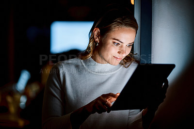 Buy stock photo Shot of a young businesswoman using a digital tablet during a late night at work