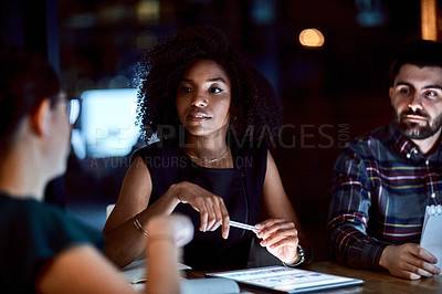 Buy stock photo Shot of a group of young businesspeople having a late night meeting at work