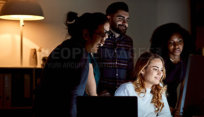 Buy stock photo Shot of a group of young businesspeople using a computer during a late night at work