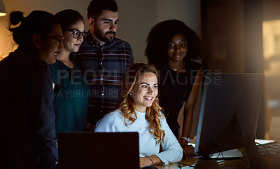 Buy stock photo Shot of a group of young businesspeople using a computer during a late night at work