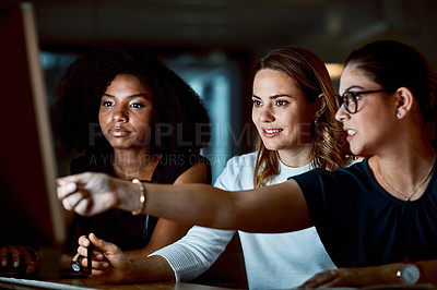 Buy stock photo Shot of a group of young businesswomen using a computer during a late night at work